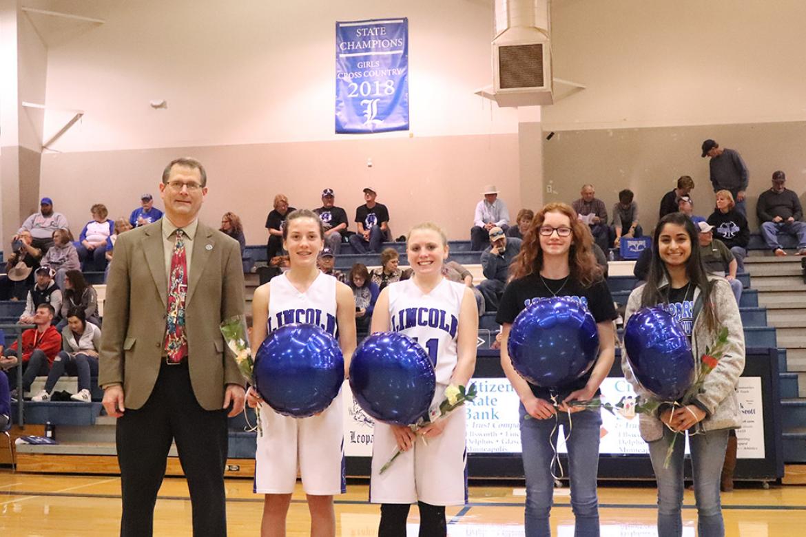 The Lincoln girls cross country team was honored for their 1A Cross Country Championship during Tuesday night's basketball games. Left-to-right: Coach Steve Crist, freshman Raegan Stewart, sophomore Jaycee Vath, freshman Shelbie Ford and senior Aubry Donley. (Photo courtesy Kae Hayworth)